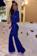 Woman in a royal blue sequin jumpsuit with flared legs, angled side view.