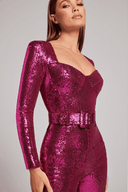 Magenta sequin jumpsuit with long sleeves, sweetheart neckline, and belted waist, angled view.