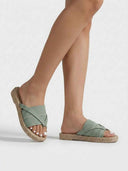 Crossover knit flat mule sandals in sage green — angled view showing ribbed-knit strap detail.