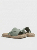 Close-up of ribbed-knit crossover strap and rope-trim espadrille midsole on flat slide sandal.