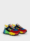 Side profile of chunky lace-up trainers with rainbow sole, showing blue mesh upper, black suede overlays and green heel counter.