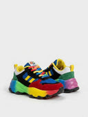 Detail close-up of chunky trainer sole and upper panels — rainbow gradient bubble sole, red toe cap and yellow stripe accent detail.
