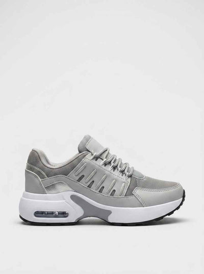 Air cushion chunky trainers in grey - front view showing mesh upper, drip-slot cage panel, and white EVA midsole with visible heel air unit.