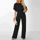 Black wide-leg jumpsuit with short sleeves and waist tie, worn by a model, front view.