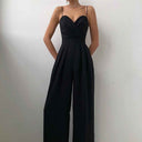 Black strapless jumpsuit with sweetheart neckline and wide pleated legs, front view.