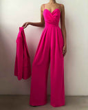 Fuchsia jumpsuit with thin straps, sweetheart neckline, and wide legs, holding a matching jacket. Front view.