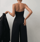 Black spaghetti strap jumpsuit with wide legs, back view.