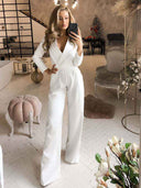 White slim-fit long-sleeve jumpsuit with a V-neck, front view in a living room setting.