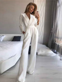 White slim-fit long sleeve jumpsuit with wide lapels and pockets, front view.
