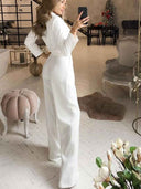 White slim-fit long sleeve jumpsuit with wide legs, angled side view in a room.