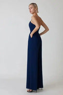 Navy blue spaghetti strap jumpsuit with flared legs and pockets, angled view.