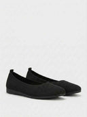Black cushioned knit flat shoe side profile showing slim flat sole and close-fitting knit upper.