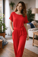 Red wide-leg jumpsuit with belted waist, front view on a home background.