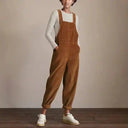 Brown corduroy boiler suit with wide legs, worn over a white long-sleeve shirt, front view.