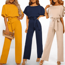 Three women in boat neck jumpsuits in mustard, navy, and beige with tie waists, front view.