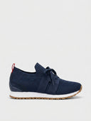 Navy knit lace-up trainer with suede panels, white sole, gum tread, and red heel pull tab, side view.
