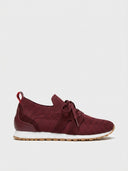 Burgundy-red knit barefoot trainer with suede-look overlays, white EVA midsole, and gum outsole, angled side view.