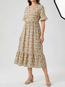 Cream floral midi dress with V-neck, short sleeves, and tiered skirt, front view.