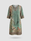 Green midi dress with floral and scroll patterns, V-neck, and elbow sleeves, front view.