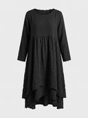 Black long-sleeve mini dress with ruffled neckline and tiered asymmetrical hem, front view.