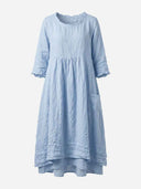 Light blue linen mini dress with ruffled neckline, 3/4 sleeves, and side pockets, front view.