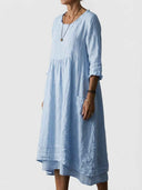 Light blue linen dress with ruffled neckline, side pocket, and layered hem, side view.