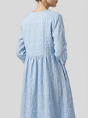 Light blue long sleeve mini dress with ruffled collar, back view.