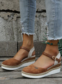 Brown closed-toe espadrille wedge sandals with white canvas heel panel and rope-wrapped wedge sole, front angled view.