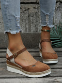 Brown closed-toe espadrille wedge sandals with adjustable ankle strap and woven rope-trim platform sole, front angled view.