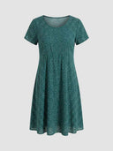 Green mini dress with white polka dots, short sleeves, and scoop neck, front view.