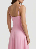 Pink mini dress with spaghetti straps and back zipper, angled back view.