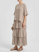 Beige tiered maxi dress with short sleeves and round neck, front view.