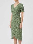 Green floral mini dress with puff sleeves, buttoned front, and wrap skirt, angled view.