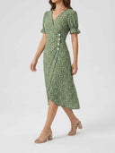 Green floral wrap dress with puff sleeves and white buttons, angled front view.