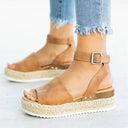 Brown espadrille flatform sandal with ankle buckle strap and woven jute espadrille platform sole, angled front view on foot.