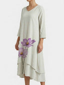 Light gray maxi dress with purple floral print, V-neck, and tiered hem, angled front view.