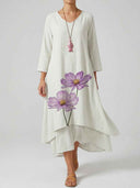White maxi dress with purple floral print, V-neck, and pink fish necklace, front view.
