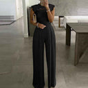 Black jumpsuit with lace top, wide legs, and pleated waist, front view.