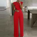 Red jumpsuit with lace cap sleeves and wide-leg pants, front view in a modern room.
