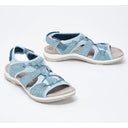 Light blue closed toe cushioned walking sandals with woven lattice upper, adjustable heel strap and flat white sole, front and side view.