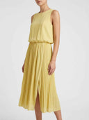 Yellow sleeveless maxi dress with pleated skirt and side slit, angled view.