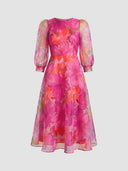 Pink floral mini dress with sheer long sleeves, front view on a white background.