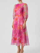 Pink floral mini dress with sheer long sleeves, side view.