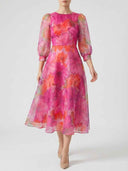 Pink and orange floral midi dress with sheer long sleeves, front view on white background.