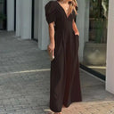 Black jumpsuit with puff sleeves, deep V-neck, and wide legs, angled view.