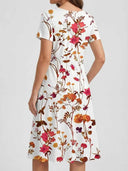 White mini dress with short sleeves and colorful floral print, back view.