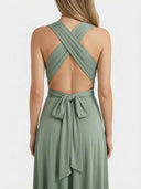 Sage green mini dress with criss-cross back straps and a tied bow at the waist, back view.