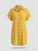 Yellow textured shirt dress with rolled short sleeves, brown buttons, and two front pockets, front view.