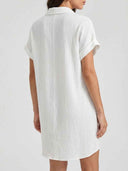 White textured mini shirt dress with rolled sleeves, shown from the back on a light background.