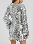 Silver sequin mini dress with long sleeves and back zipper, rear angled view.
